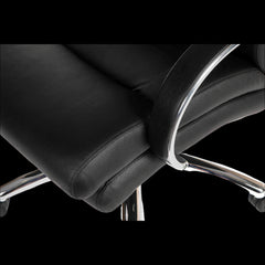 Close-up of a black office chair with chrome accents on a black background