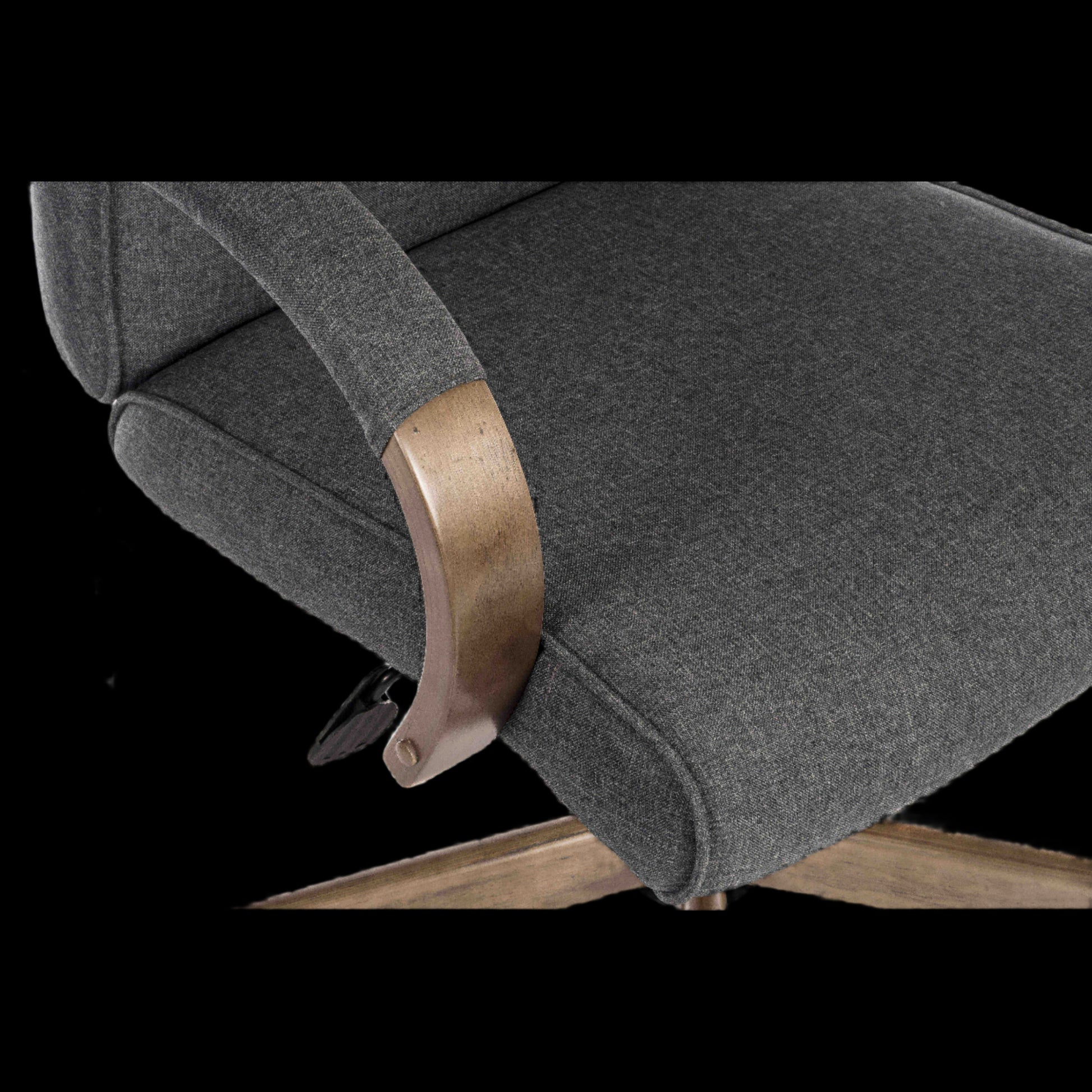 Gray upholstered chair with wooden armrest on a black background