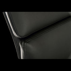 Close-up of a black leather chair with a focus on the seat and backrest.