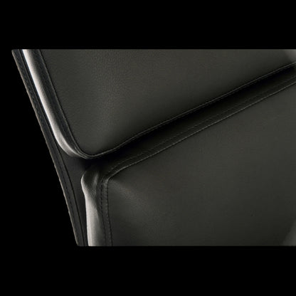 Close-up of a black leather chair with a focus on the seat and backrest.