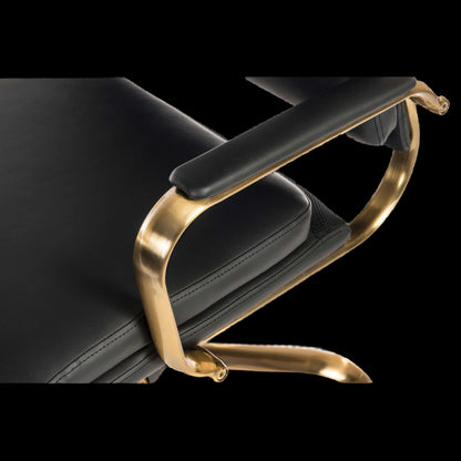 Black leather chair with gold metal armrest on a black background
