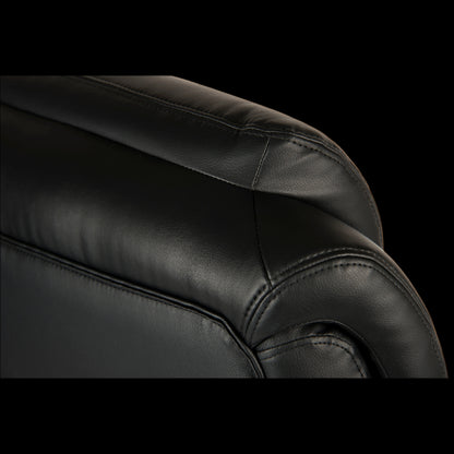 Close-up of a black leather armchair with visible stitching on a black background