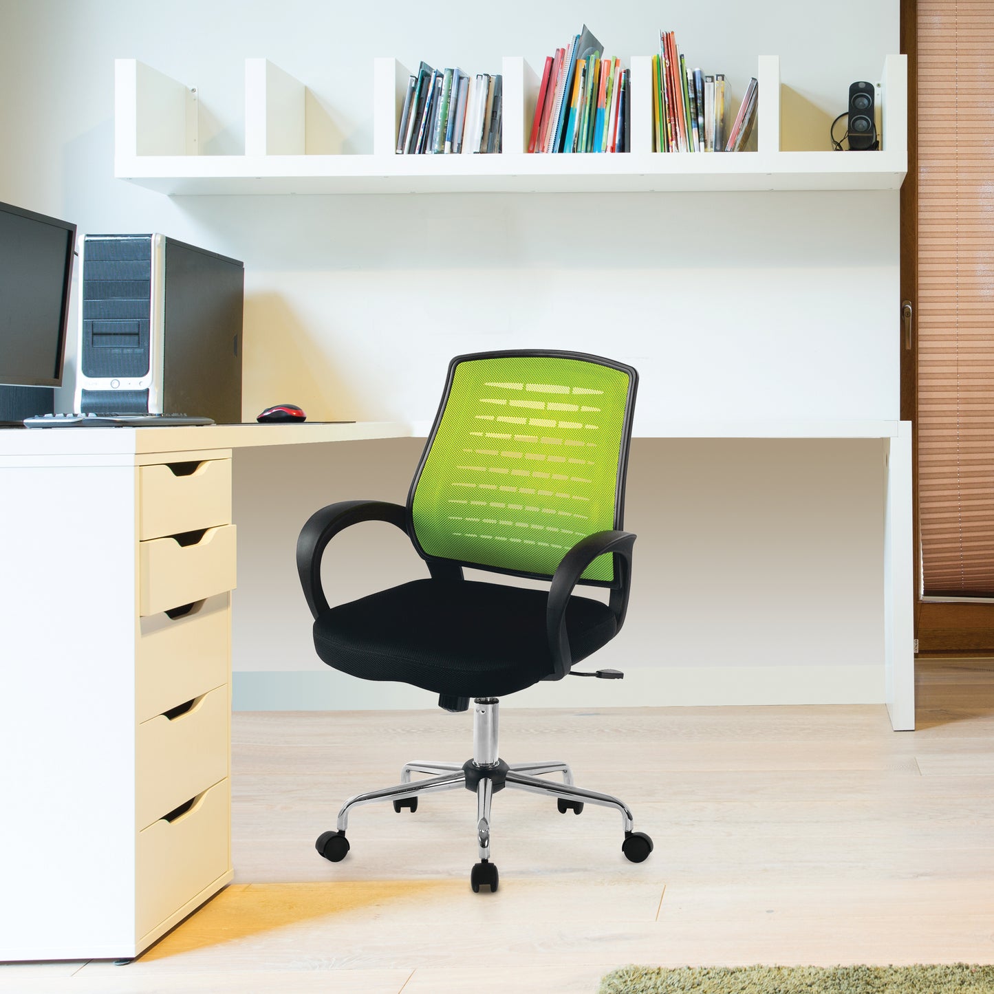 Green office chair in front of a desk with books on a shelf.