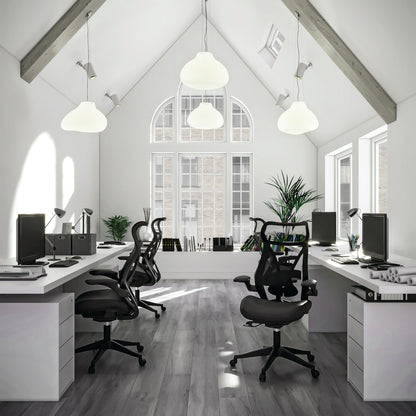 Modern office space with white desks, black chairs, and large windows.