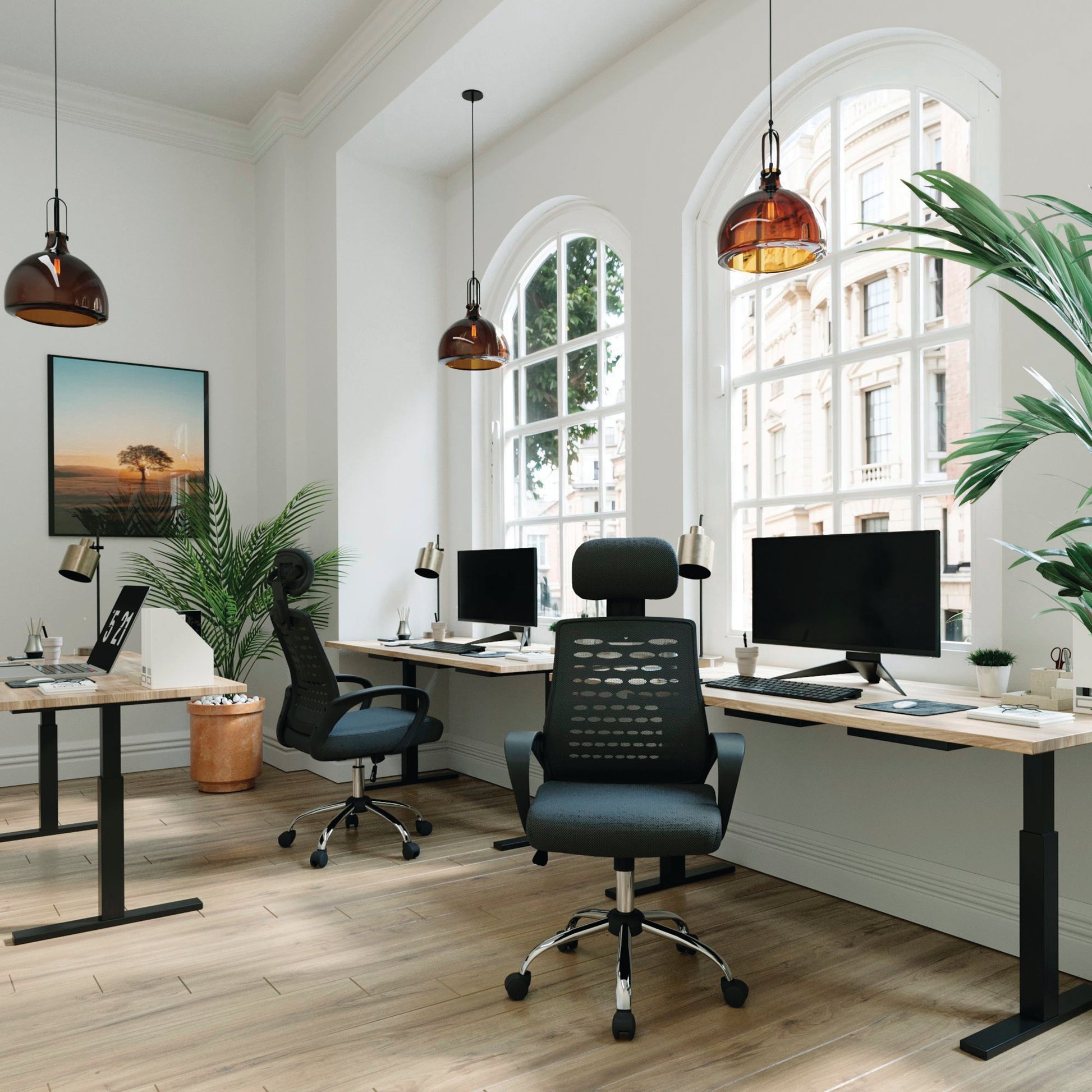 Modern office setup with ergonomic chairs, desks, and large windows.