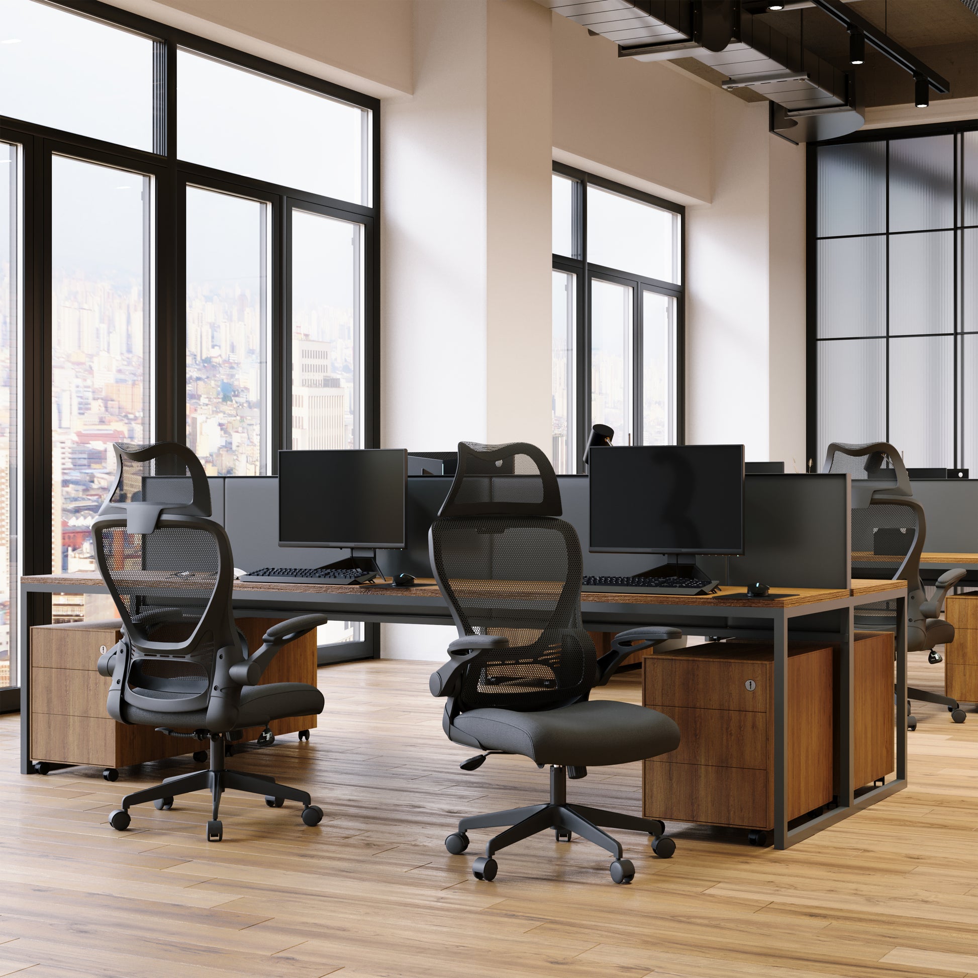 Modern office with desks, chairs, and large windows overlooking a cityscape.