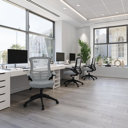 Modern office with desks, chairs, and large windows.