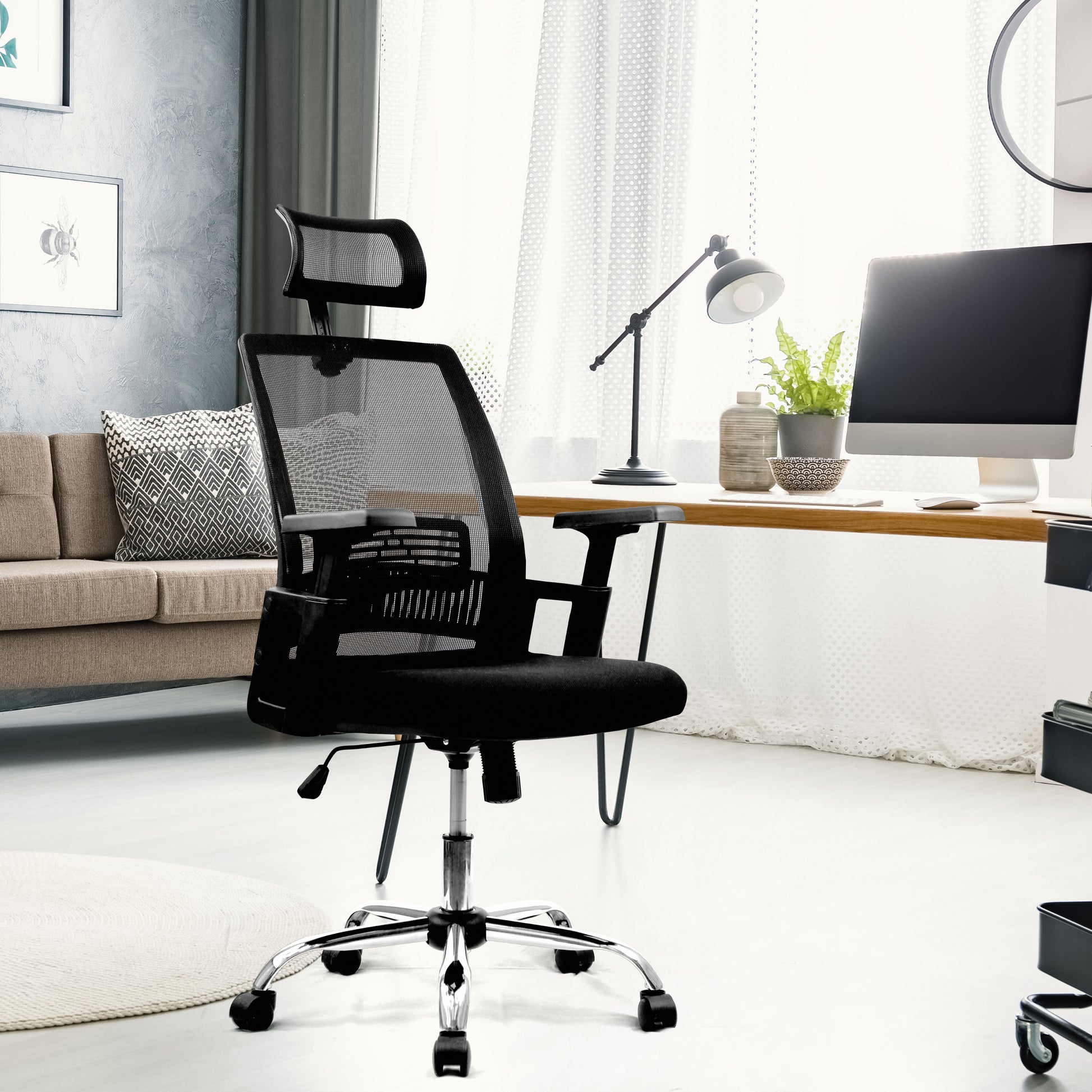 Black office chair in a modern home office setting with a desk and computer.