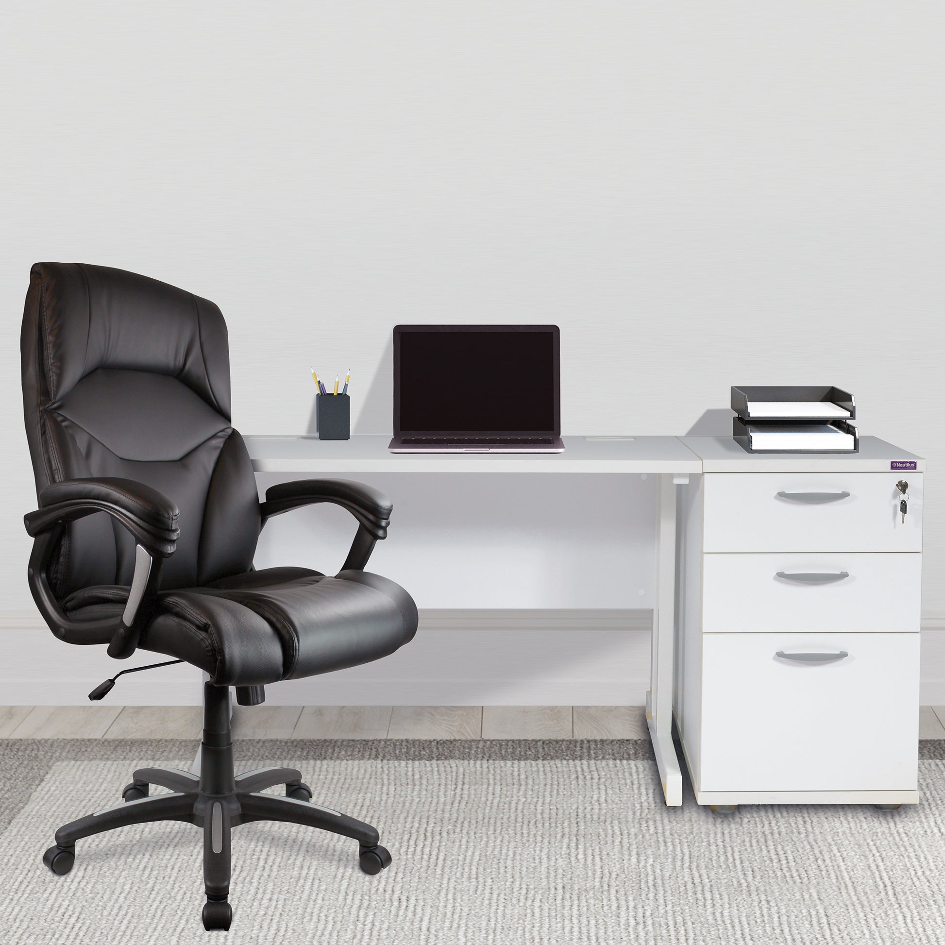 Black office chair in front of a white desk with a laptop and office supplies.