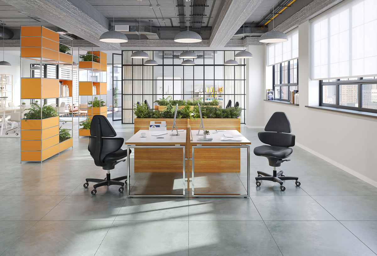CoreChair Elite at two desks in an open-plan office with planted screens