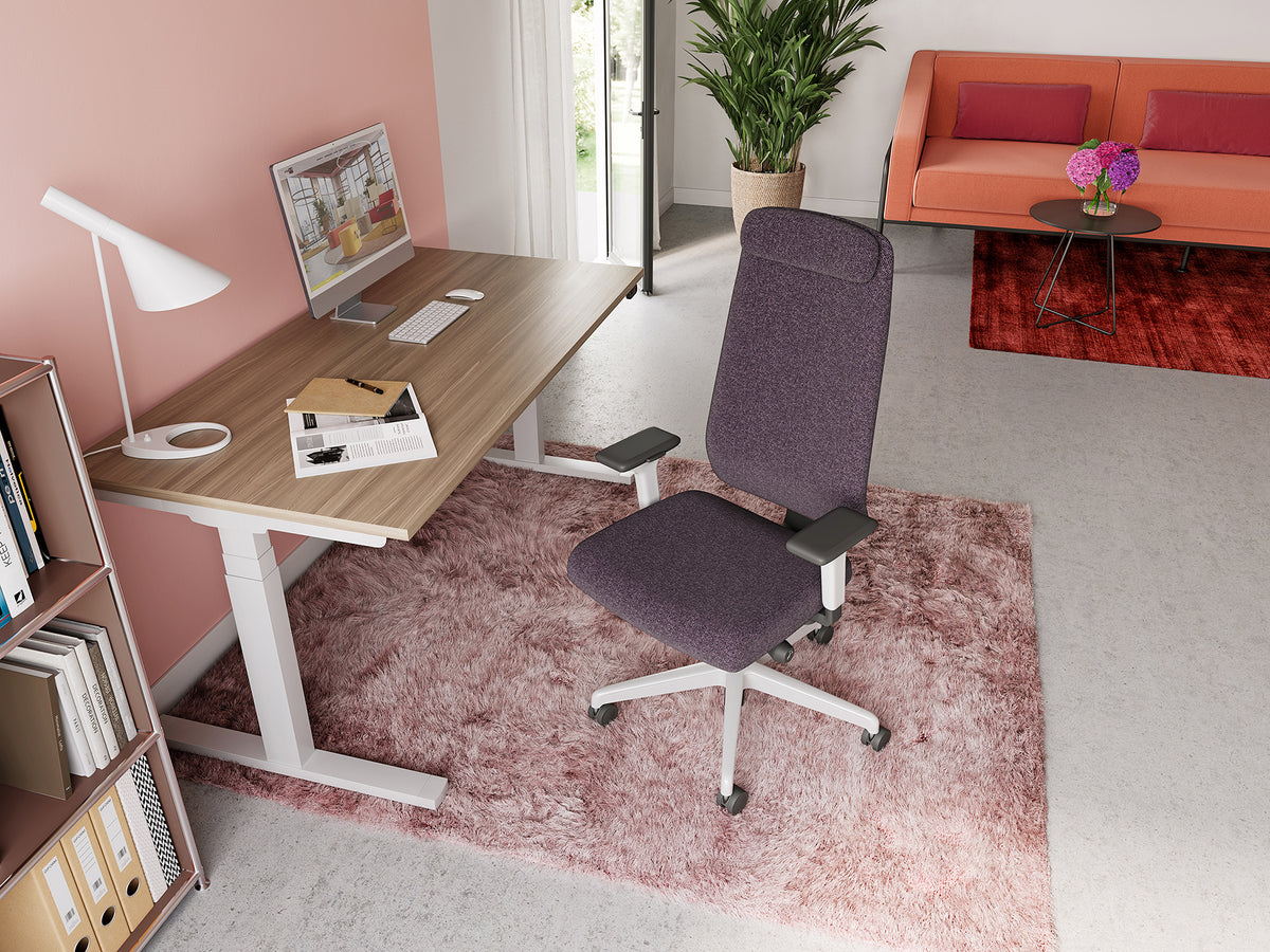Prompt Task Chair with headrest at a height-adjustable desk in a home office