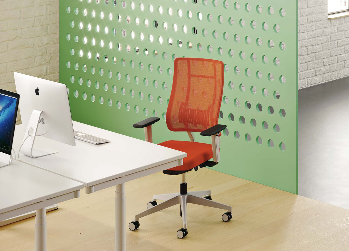 Newback Mesh Task Chair with a coloured mesh backrest at a desk against a perforated screen